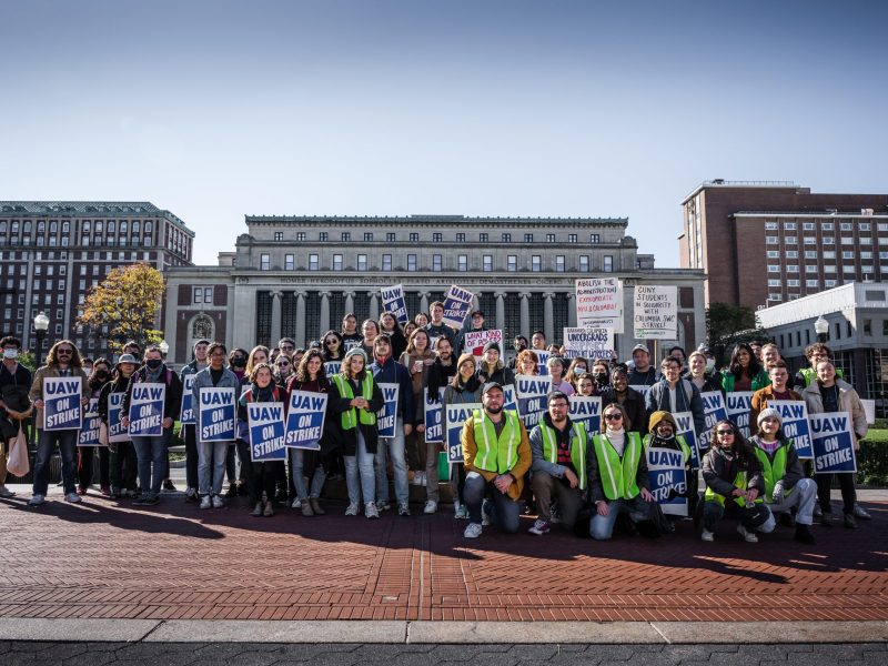 Striking Columbia student workers rally with UAW signs