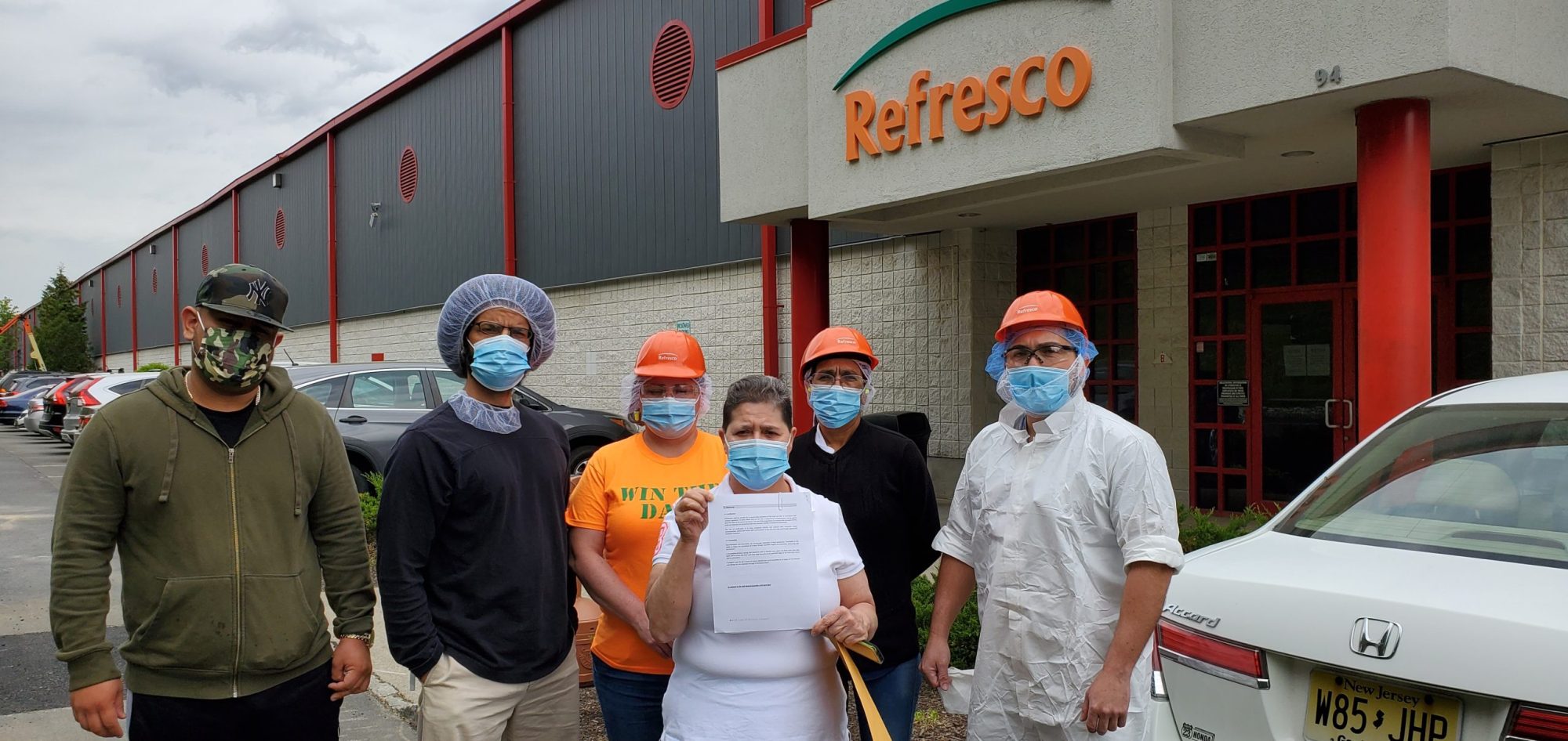 Los trabajadores de Refresco afuera de la fábrica sosteniendo una carta en la que piden a la empresa el reconocimiento voluntario poco después de presentar una solicitud de elección sindical el 3 de mayo de 2021.