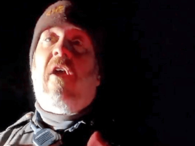 Close-up of a bearded police officer wearing a beanie